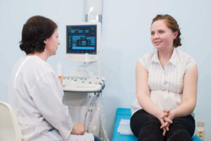 gynecologist showing ultrasound photo to pregnant utc